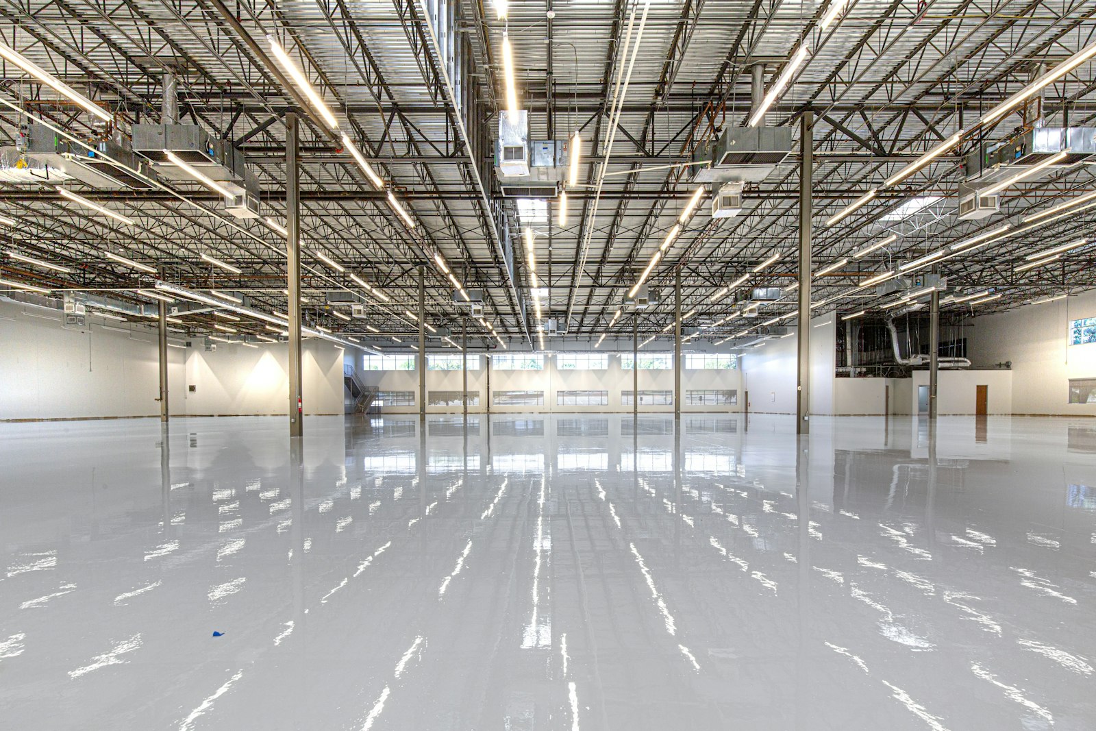 Reflective polished concrete floor under warehouse ceiling lights